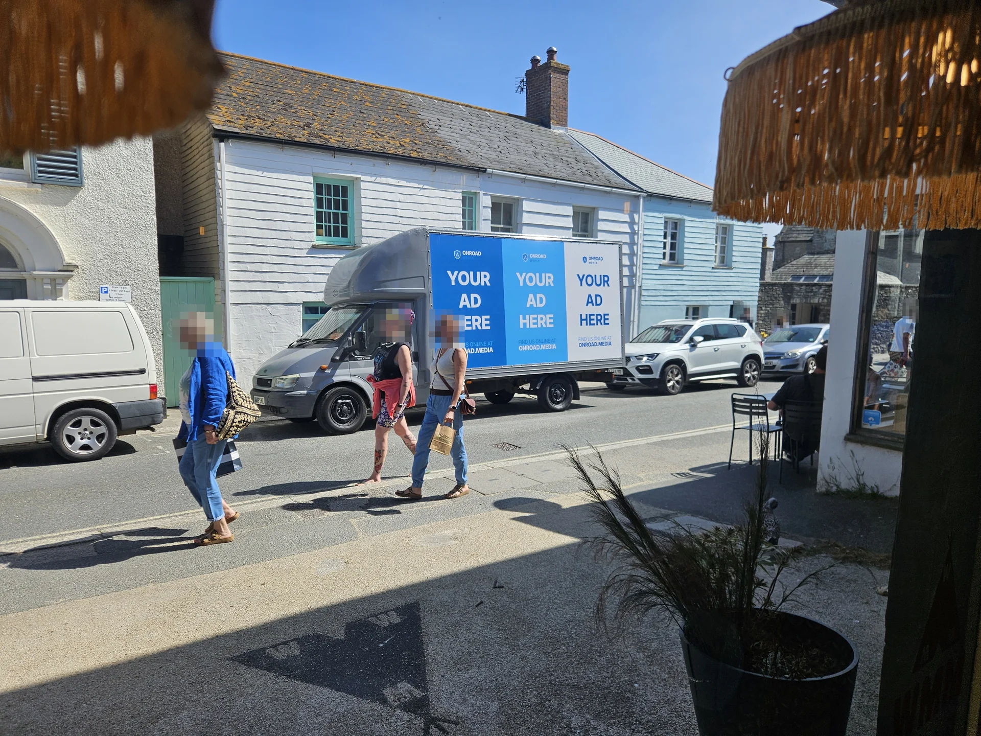 The Onroad Media billboard van with three blue advert panels parked on a sunny street in Newquay.