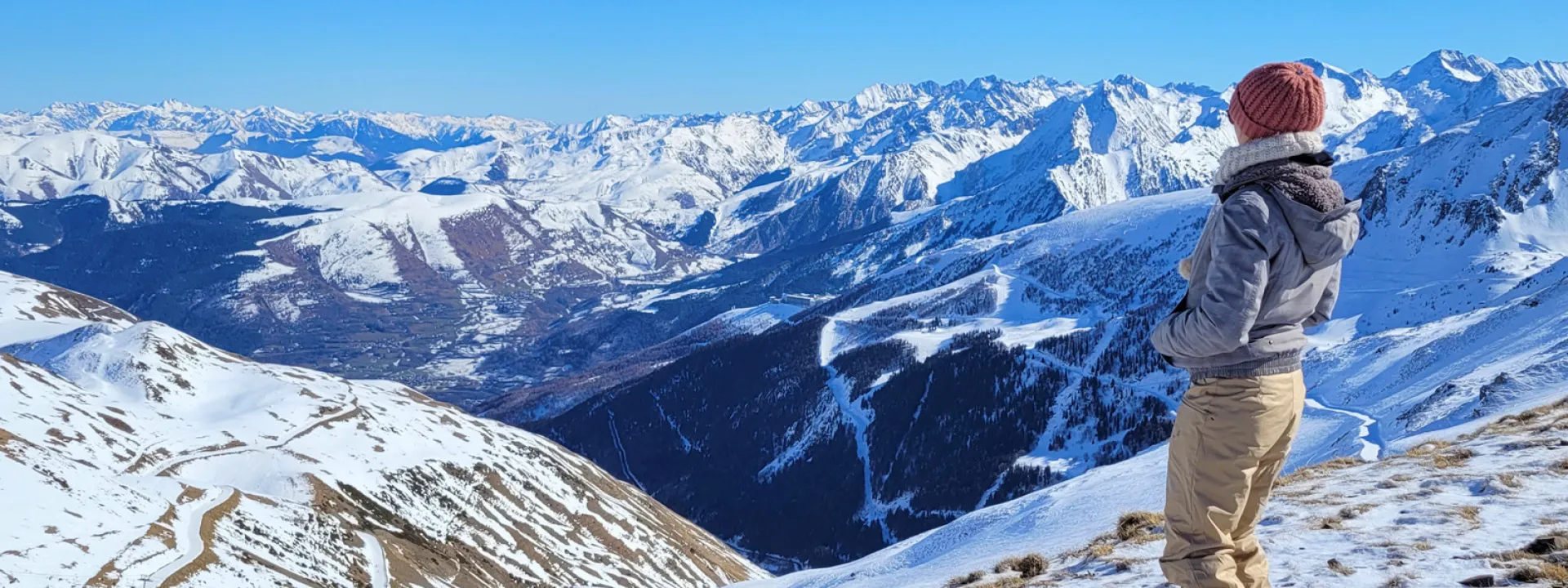 A visitor looking across the snow-covered Pyrenees mountains at Saint-Lary-Soulan.